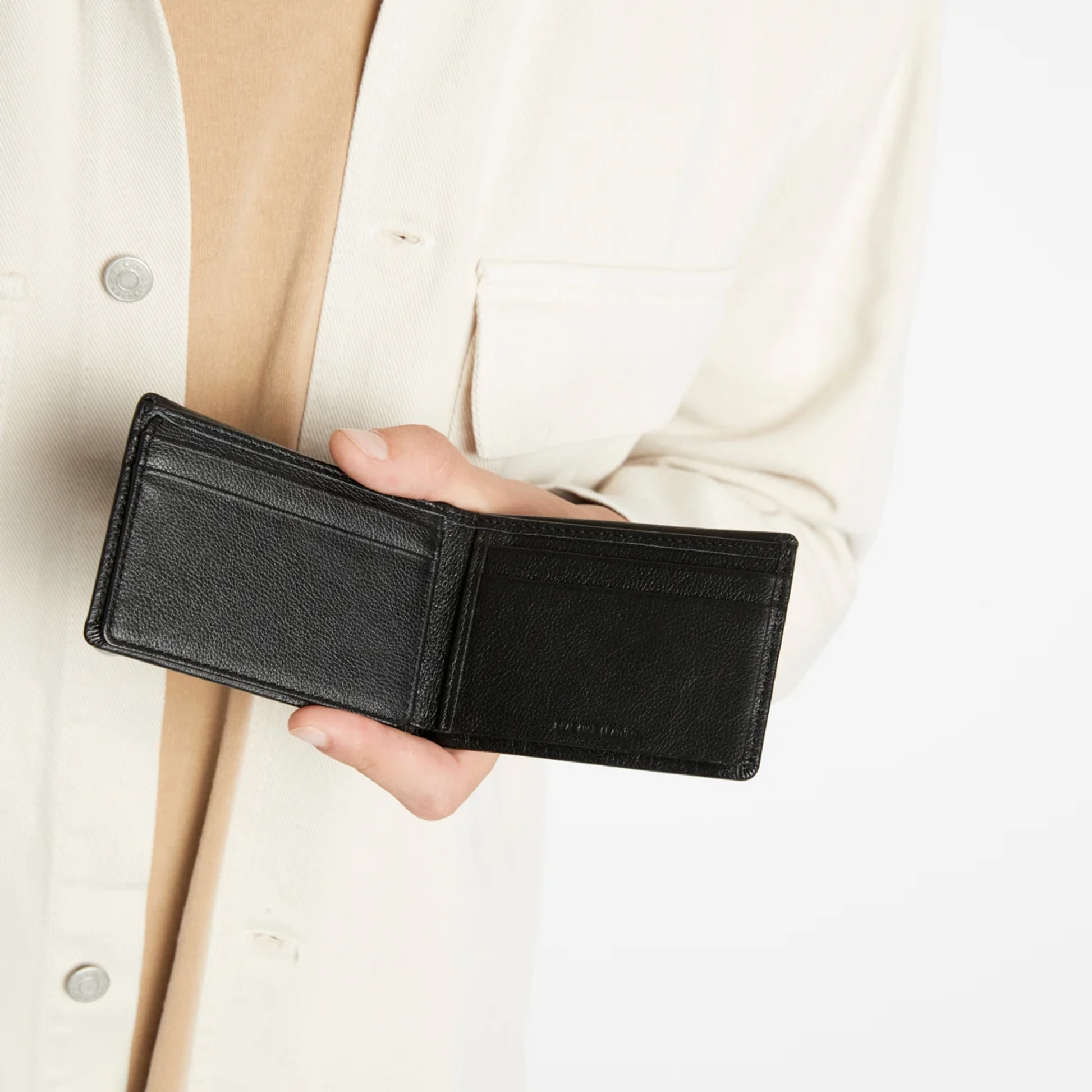 Open Status Anxiety Wallet Jonah Black from premium Italian leather with 6 card slots, and fits AUD & USD, held.