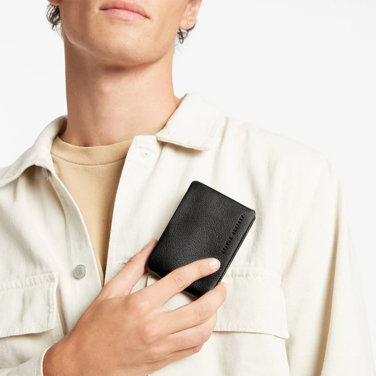 Status Anxiety Wallet Jonah Black from premium Italian leather with 6 card slots, and fits AUD & USD, held chest level.