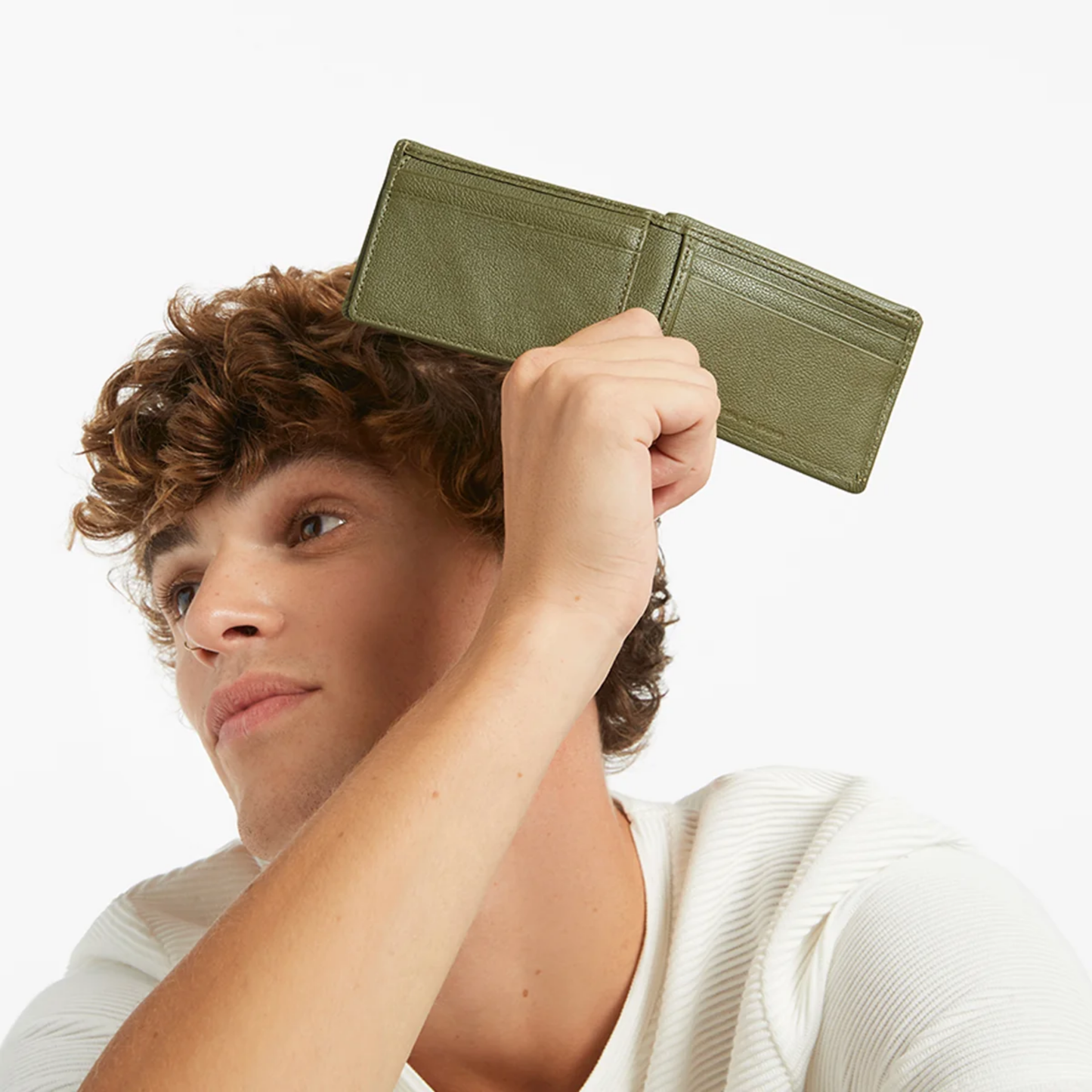 Open Status Anxiety Wallet Jonah Khaki from premium Italian leather with 6 card slots, and fits AUD & USD, held by a man.