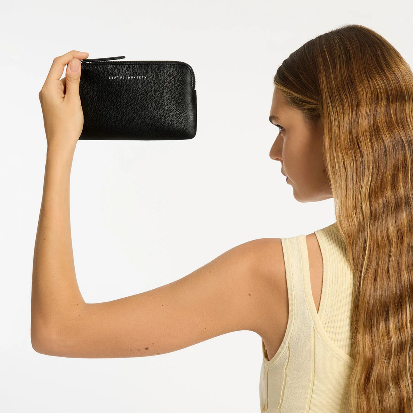Front view and held up Status Anxiety Wallet Smoke And Mirrors Black from soft shrunken pebble leather with 4 card slots.