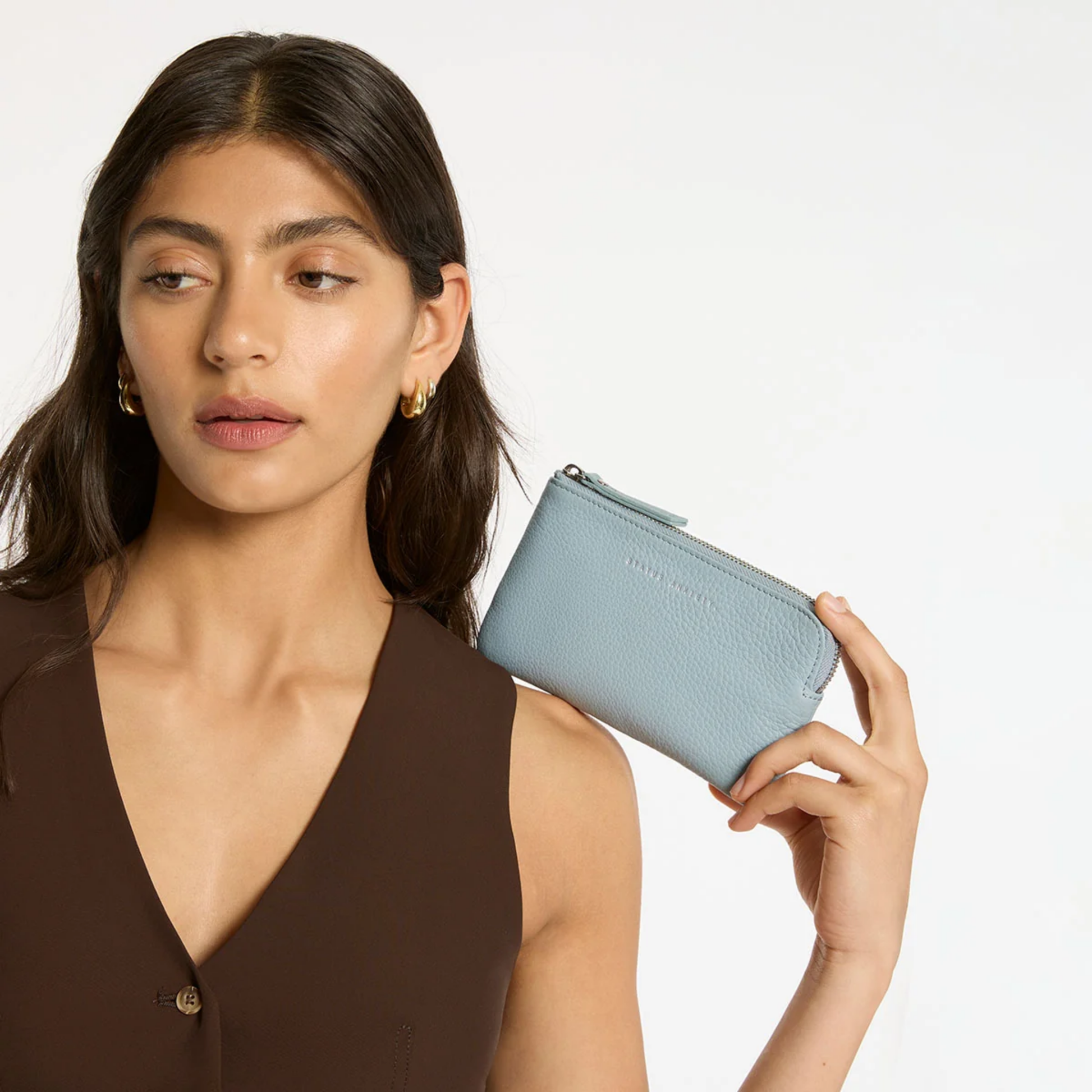 Status Anxiety Wallet Smoke And Mirrors Powder Blue from soft shrunken pebble leather with 4 card slots, held shoulder level.