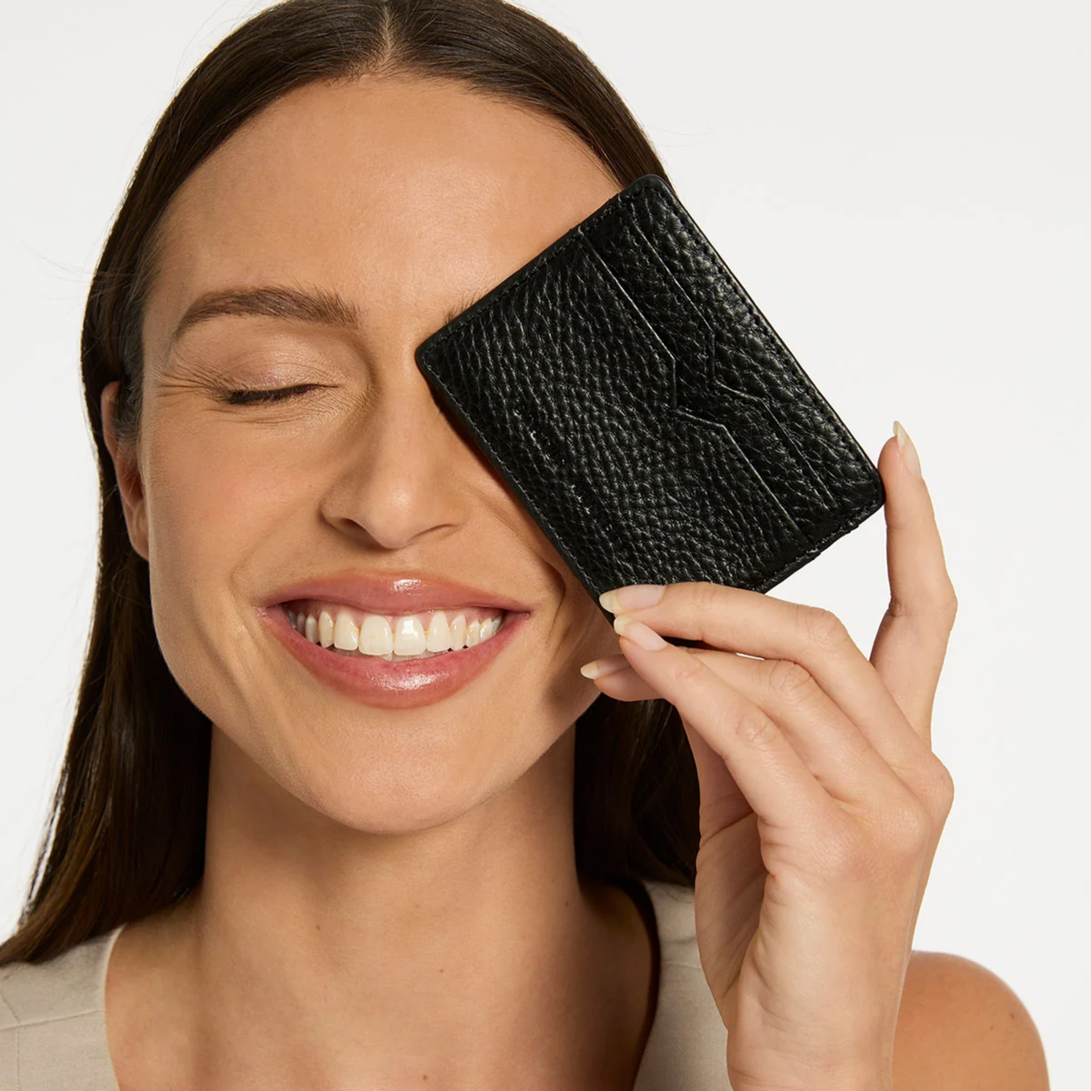 Status Anxiety Wallet Together For Now Black Soft shrunken pebble leather with 4 card slots and stash pocket, held eye level of a woman.