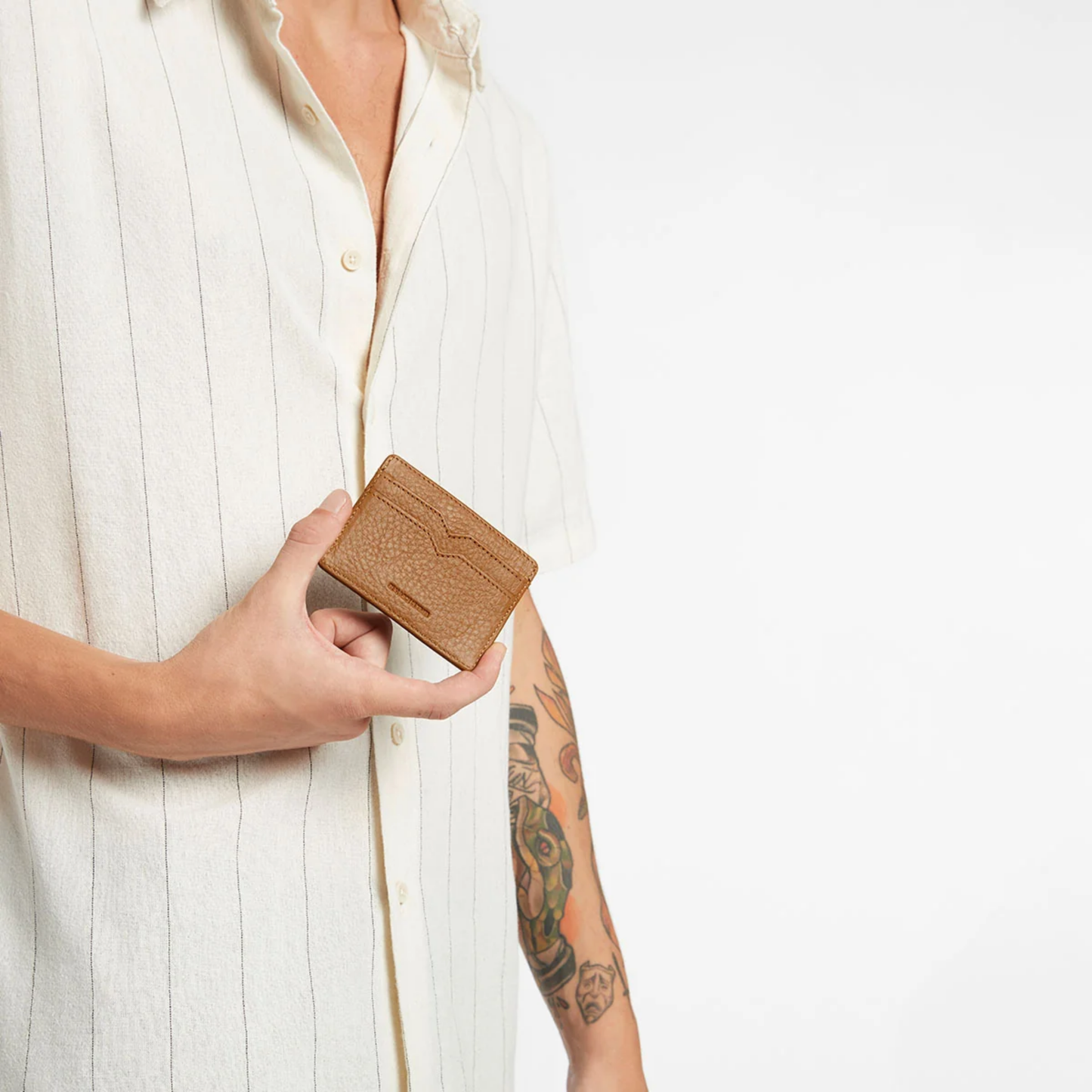 Status Anxiety Wallet Together For Now Camel Soft shrunken pebble leather with 4 card slots and stash pocket, held by a hand.