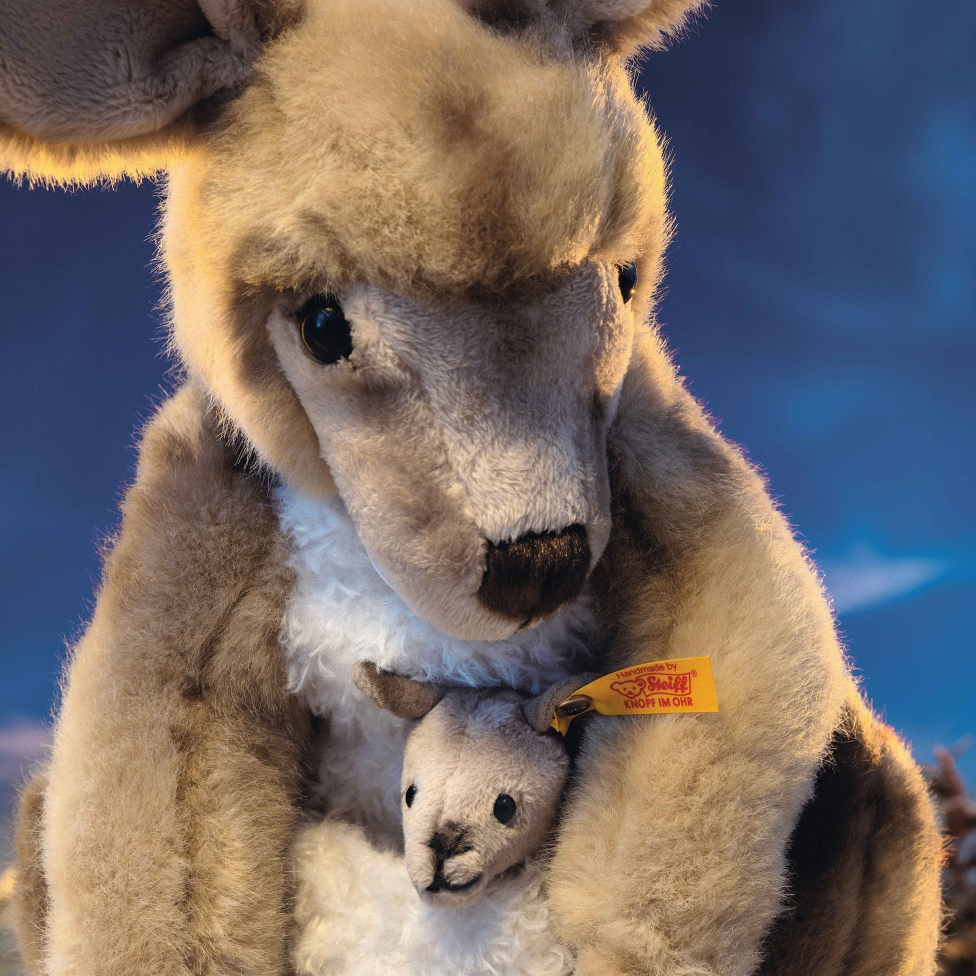 Close up of the Steiff Kangaroo with Baby 40cm, a beige-tipped coat made of cuddly soft plush, contains a little beanbag.
