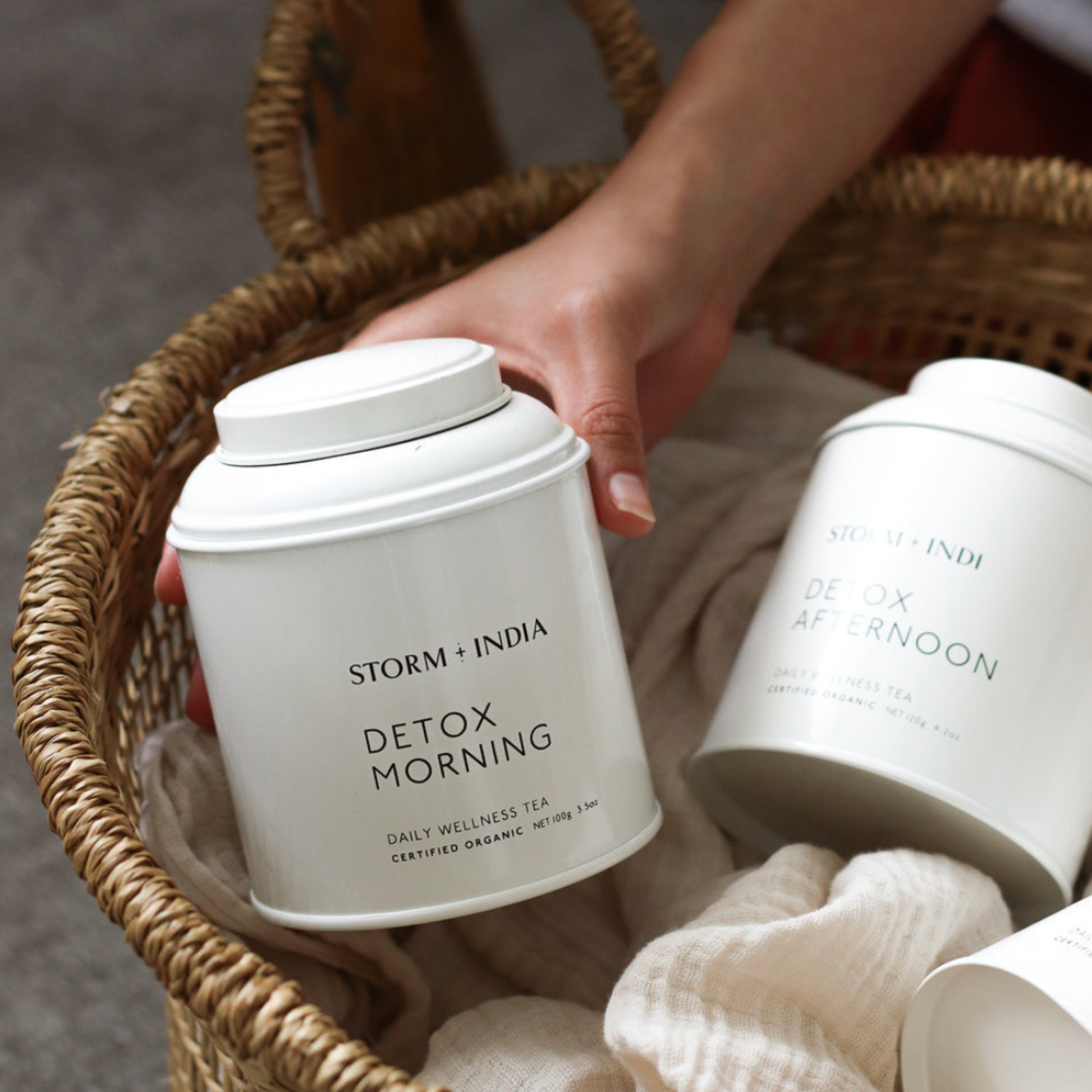 Storm and India Loose Leaf Tea in Tin 100g Detox Morning in woven basket with Storm and India Detox Afteroon Tea in Tin cushioned by blanket