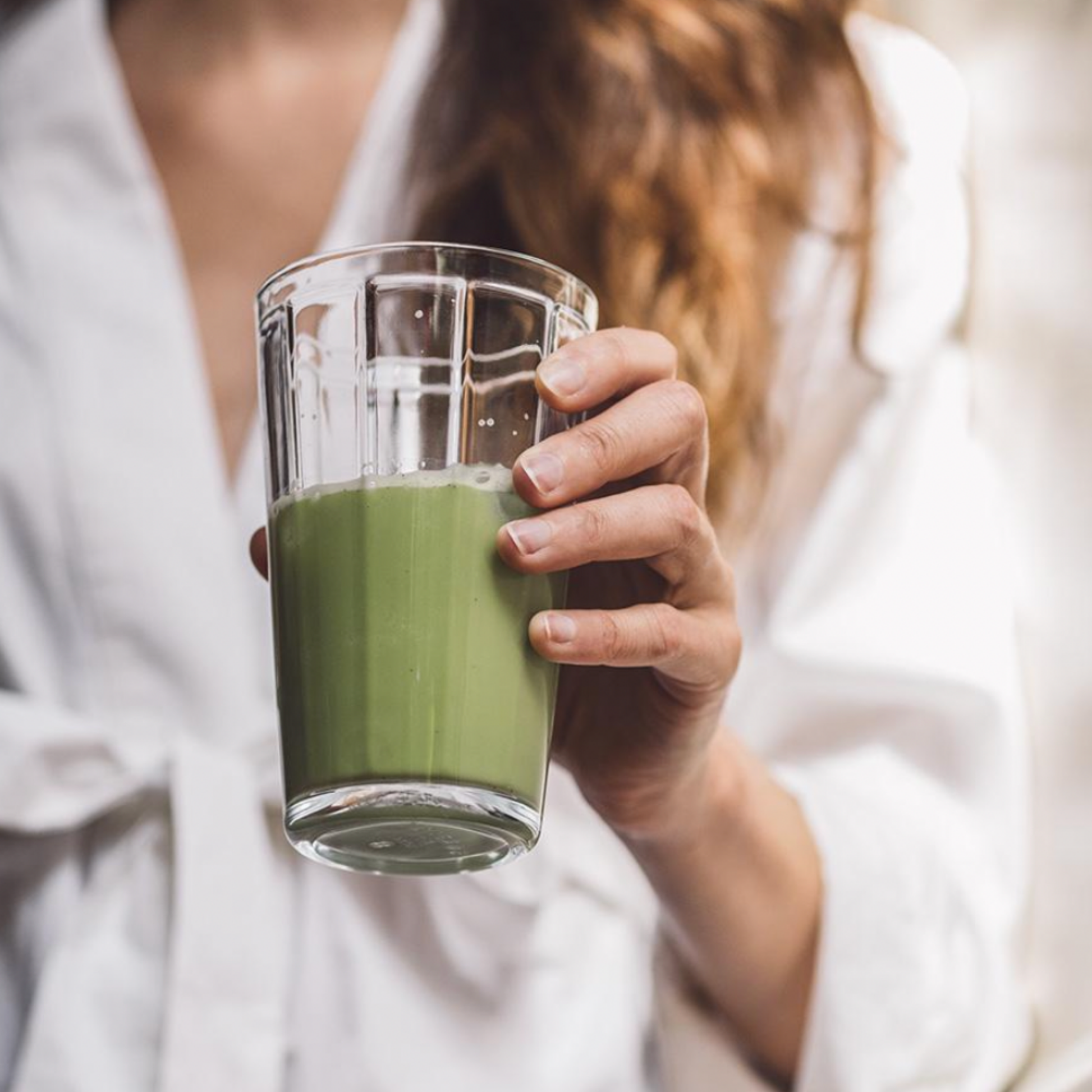 Woman holding glass of matcha 