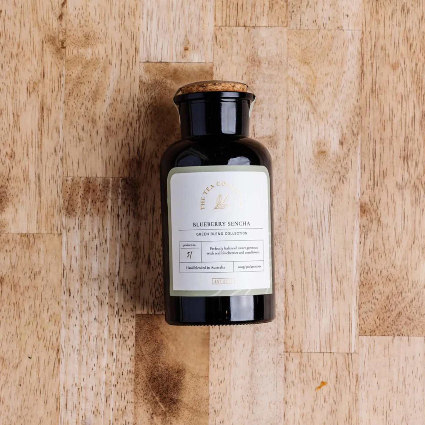 The Tea Collective loose leaf blueberry sencha tea in jar on wooden table