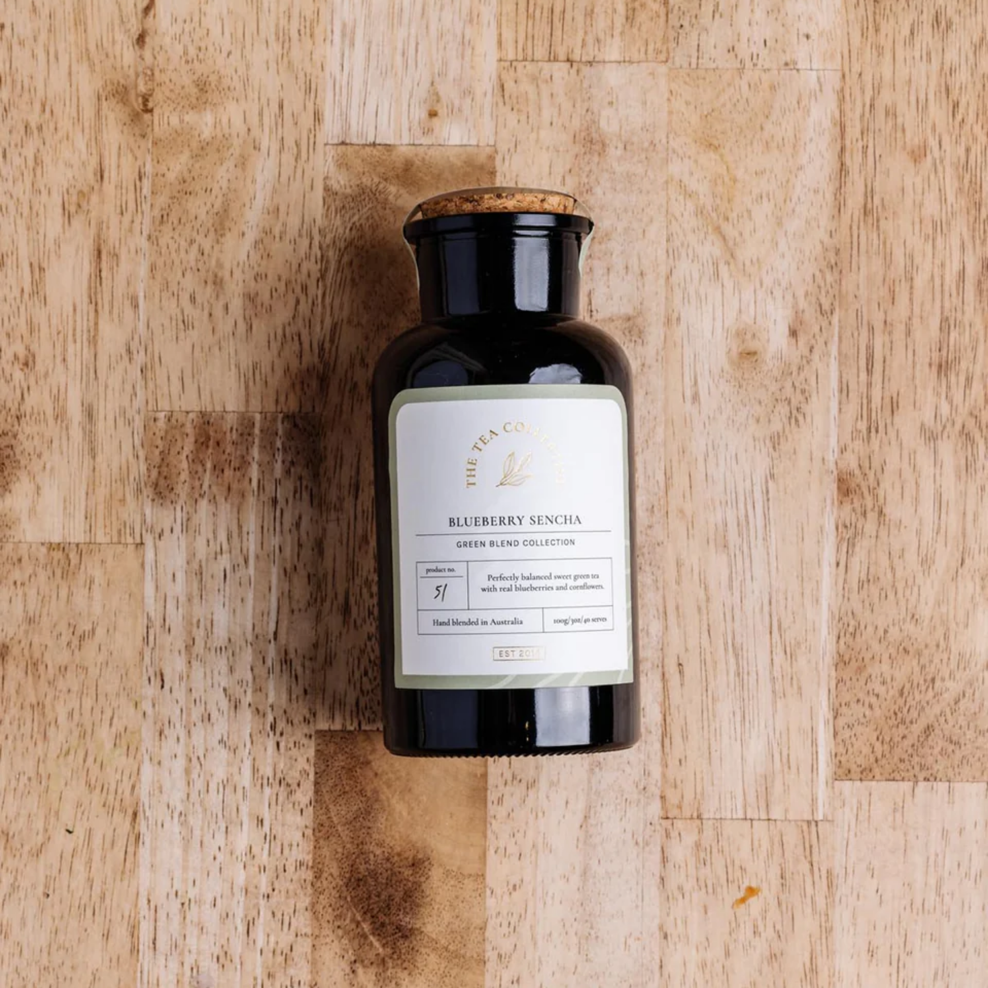 The Tea Collective loose leaf blueberry sencha tea in jar on wooden table
