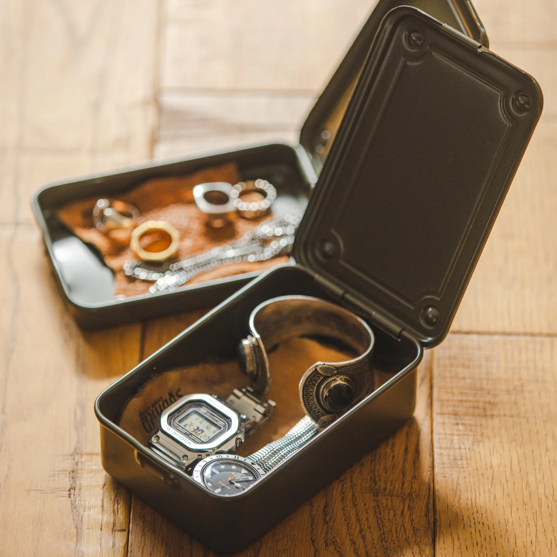Showing jewelry inside the Toyo Toolbox Trunk Shape T-150 Moss Green made from a single steel plate, lightweight and portable as general storage box.