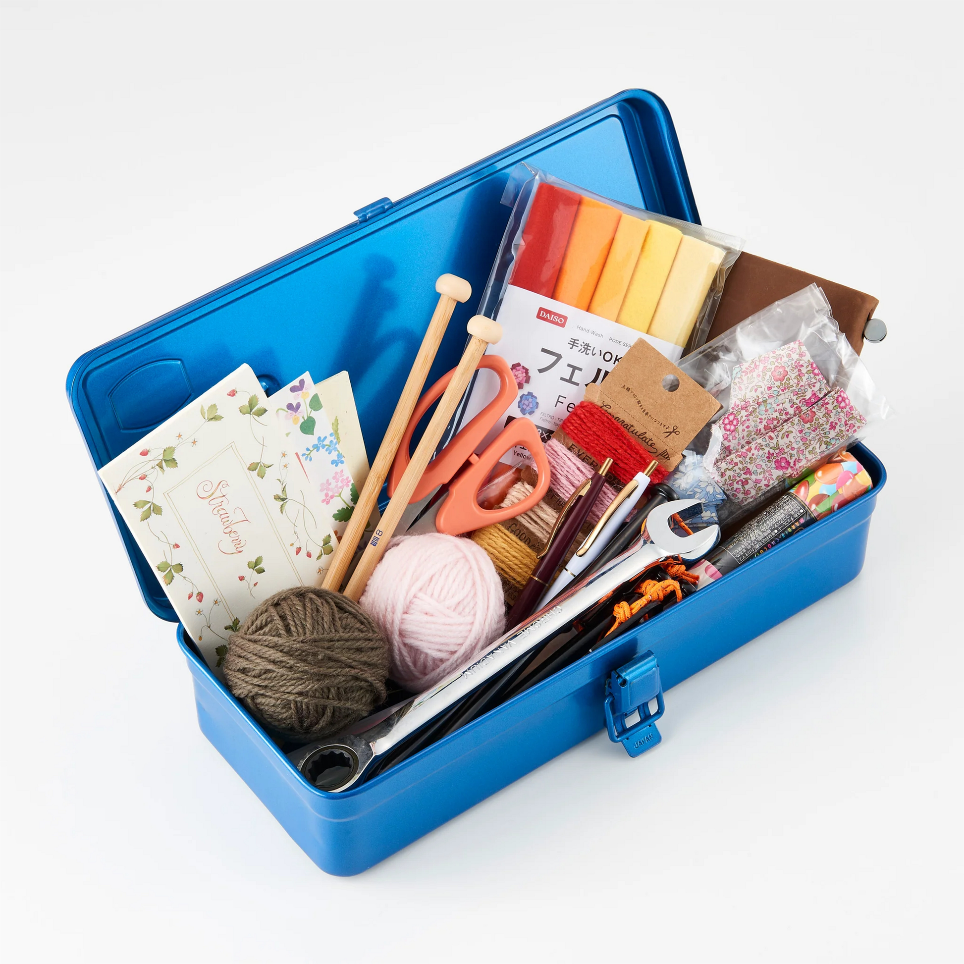 Stationary, knitting and tools seen inside the Toyo Toolbox Trunk Shape T-320 Blue with ample storage capacity and sleek stylish look.