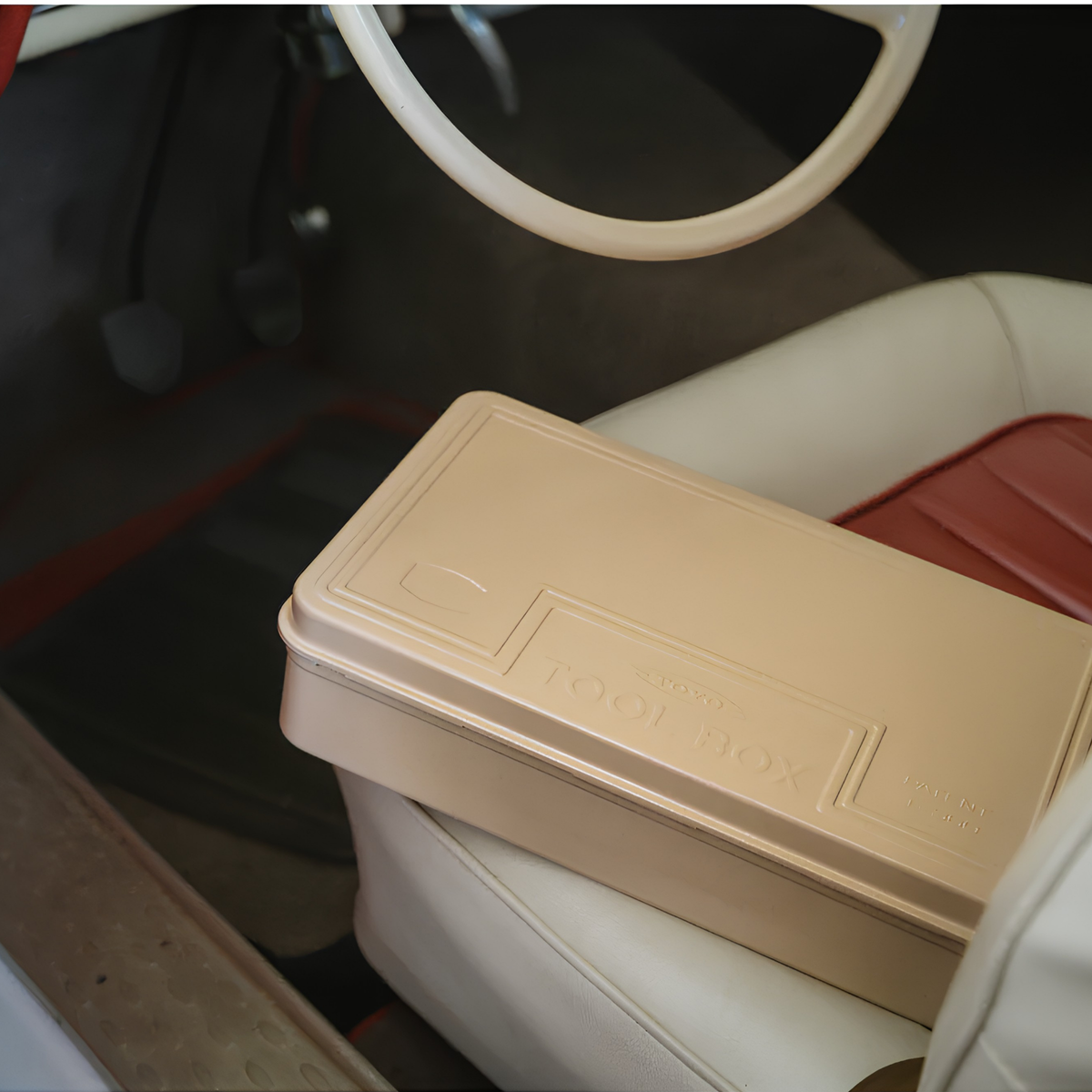 On the car seat, Toyo Toolbox Trunk Shape Toolbox T-360 Beige made from pressed steel plate, glossy with no sharp edges.