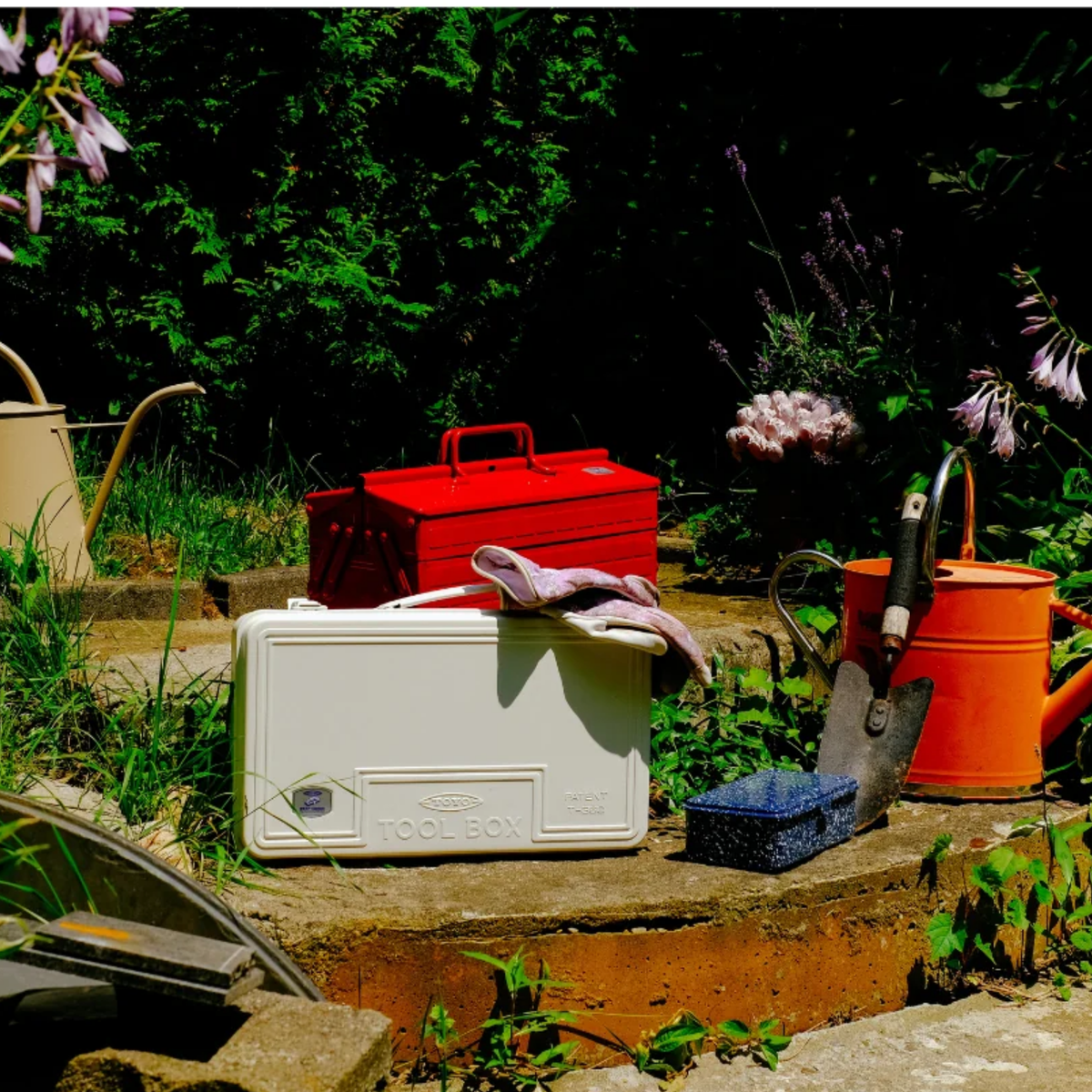Front view in the garden area of the Toyo Toolbox Trunk Shape Toolbox T-360 White made from pressed steel plate, matte with no sharp edges.
