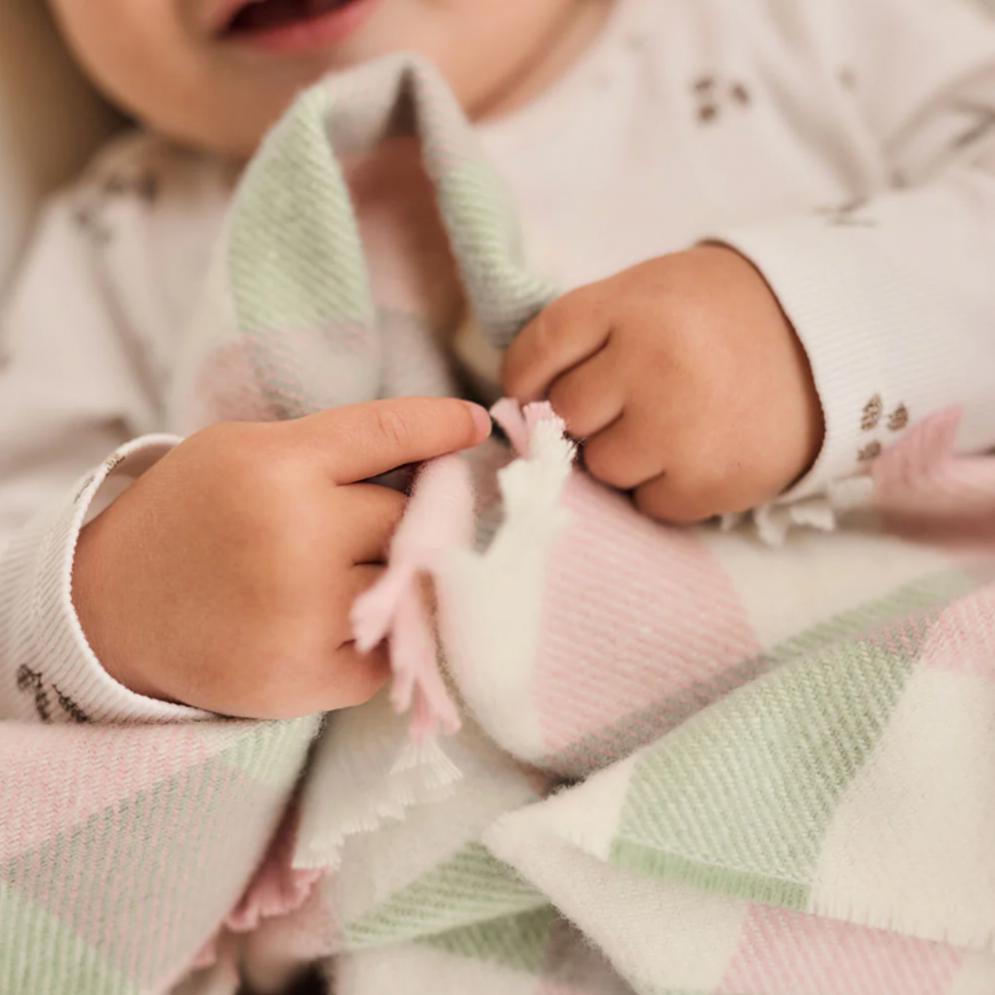 Baby lying down with Waverly Mills baby blanket 