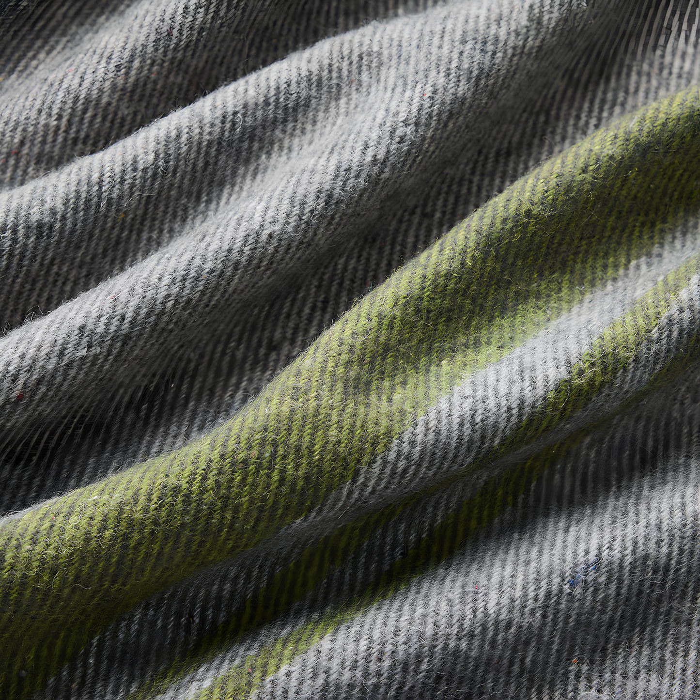 Close up of the Waverley Mills Field Blanket Charcoal from military origins, charcoal whip stitch fringe, and recycled wool in charcoal and grey with green stripe.