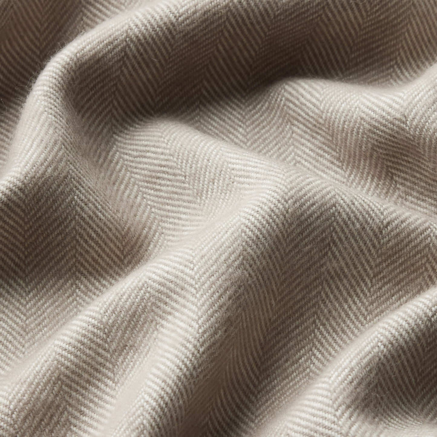 Close up view of the Waverley Mills Herringbone Throw Atmosphere classic herringbone pattern, fringed edge adds texture perfect for warmth on the sofa or foot of the bed.