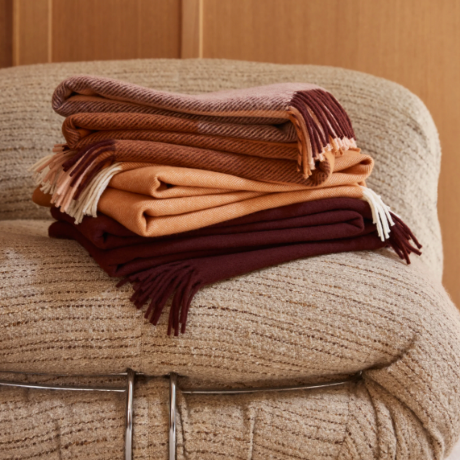 Folded assorted Waverly Mills throws on arm chair