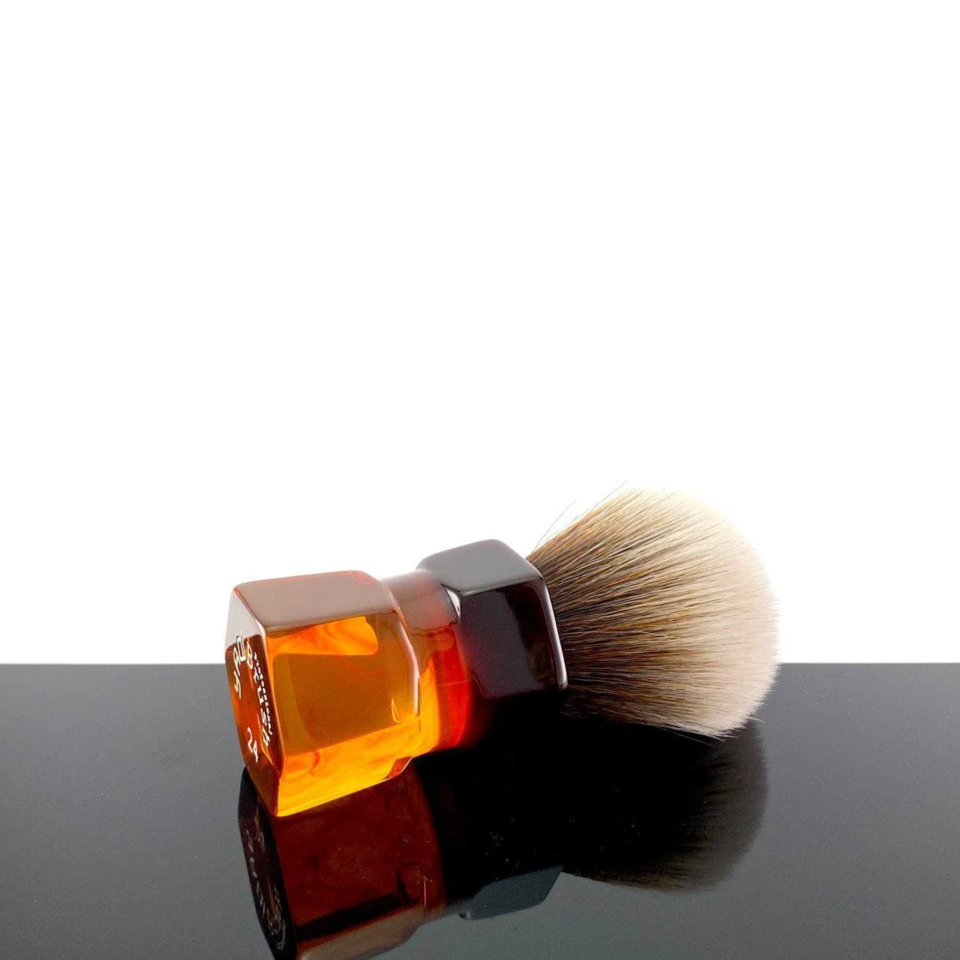 Laid down on a surface Yaqi Moka Express Synthetic Shaving Brush - Resin shaving brush with 24mm synthetic Mew Brown knot and palm-grip handle - Durable resin build with 52mm loft and 54mm handle height - Stylish smokey swirl design for smooth lathering and exfoliating shave experience