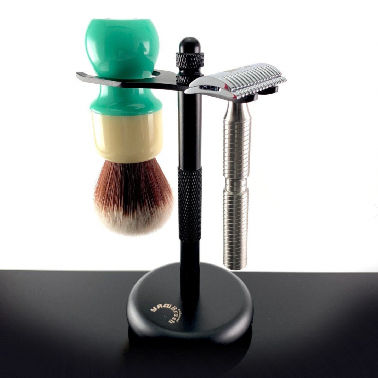 Yaqi Shaving Stand Black displayed with shaving razor and shaving brush hanging from ends 